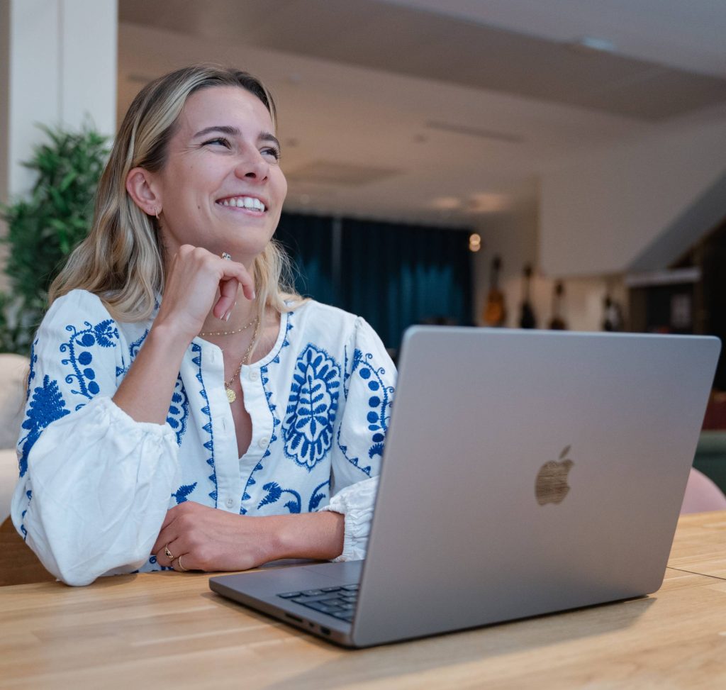 Jeune fille souriante devant un ordinateur